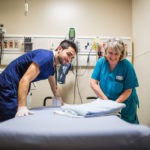 Staff member and high school student in hospital room