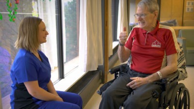 Patient in long-term care giving thumbs up to nurse